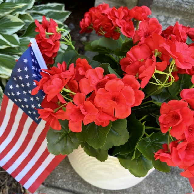 Patriotic summer porch planter with red geraniums and American flag